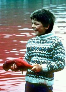 Photo-Boy holding a pilot whale featus from the Faroe islands killings that took place over the last few days...